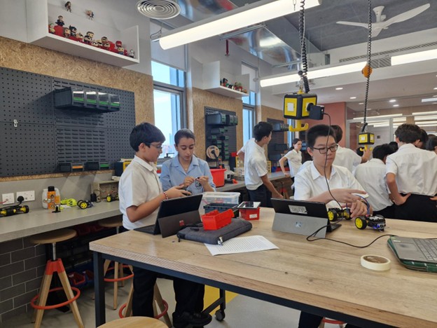 Dubai College students building robots at a DCSS robotics workshop